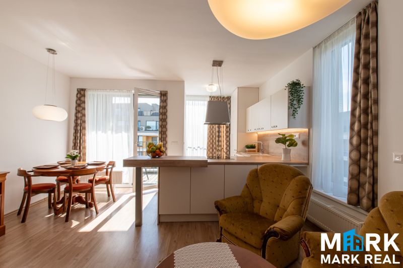 Living room connected with kitchen, dining table, wooden decor flooring, light curtains.