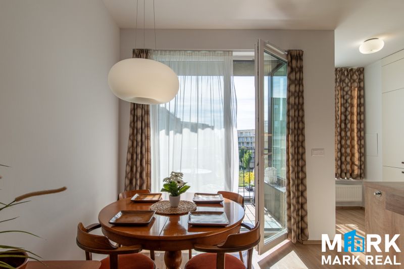 Dining area with a round table and chairs in a 2-room apartment.