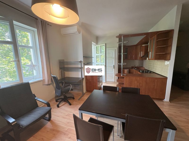 Living space with a kitchen and dining table in a 2-room apartment, floor with wooden decor.