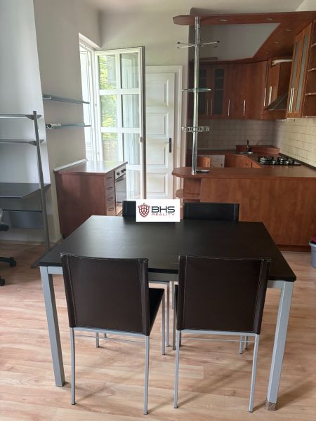 2-room apartment with a kitchen and dining area, wooden decor flooring, dark wood furniture.