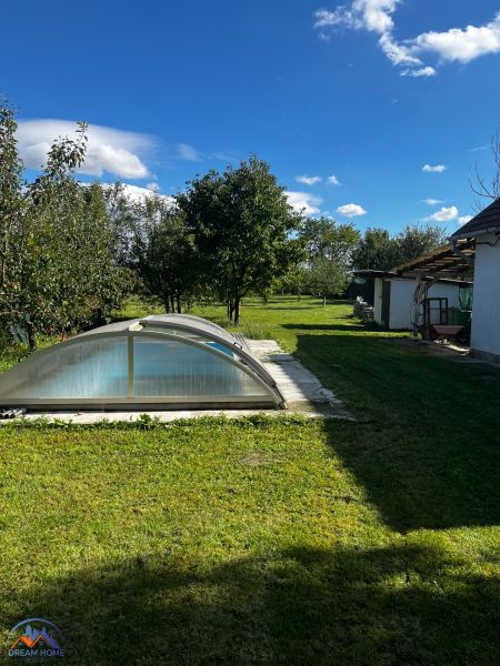 A family house in Čalovecká garden with a pool under an arched cover and a grassy area.
