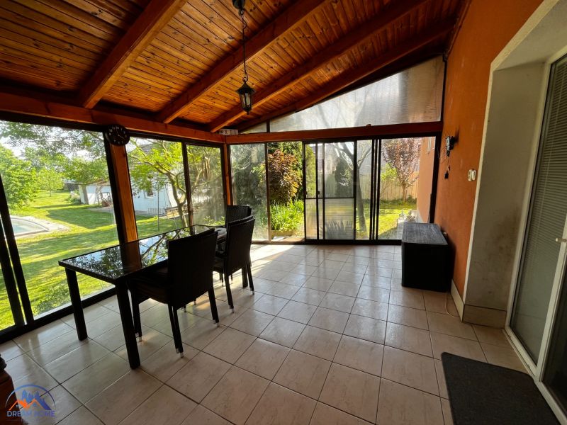A glazed terrace in a family house with a view of the garden.