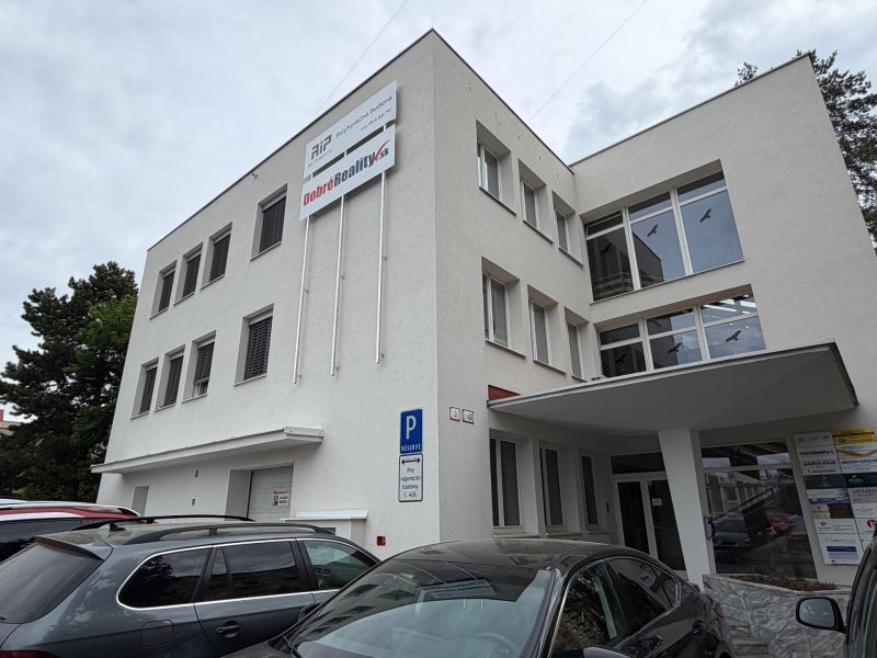 Office building on Dlhá Street in Prievidza with parked cars.