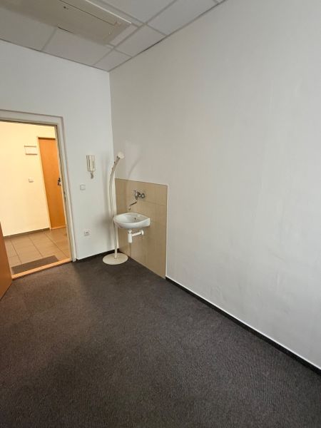 Offices with carpet, sink, and white walls.