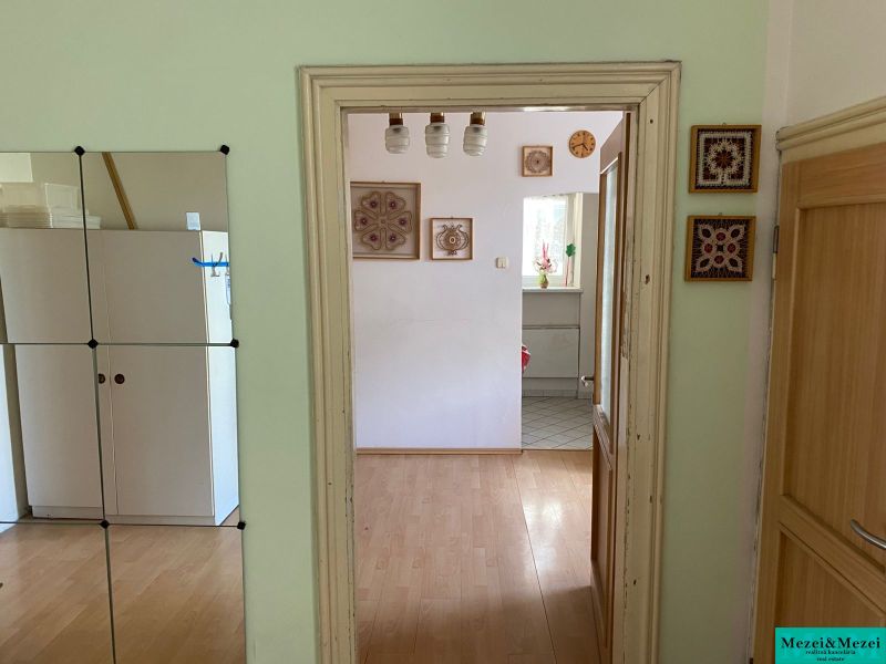 There is a wooden floor decor, a mirror, and decorations on the wall.