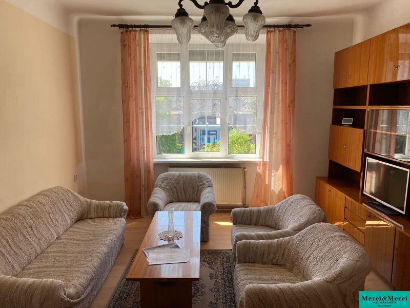 Living room in a two-room apartment with a sofa, armchairs, TV, and furniture.