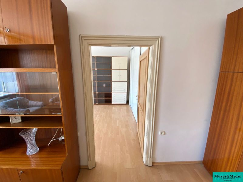Interior of a 2-room apartment with a wooden decor floor and wooden furniture.