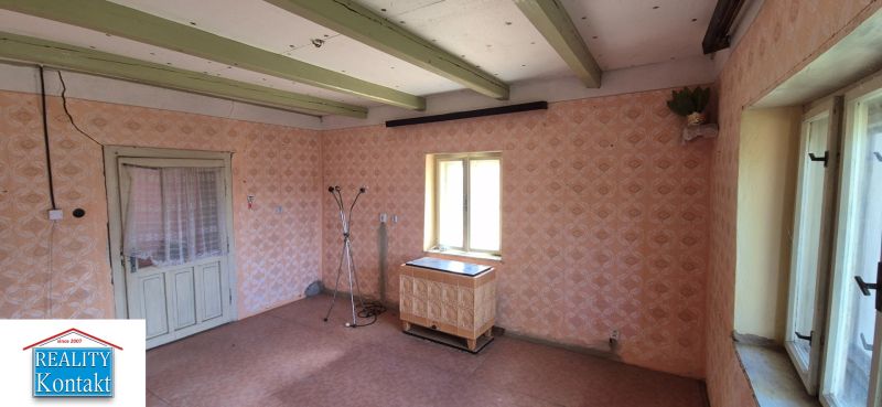 A room in a family house with retro wallpaper, a heating unit, and a floor with a wooden decor.