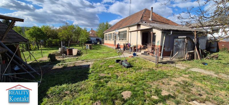 No Village: Family house with a garden and an annex, with a lawnmower on the lawn.