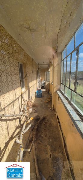 The family house has an enclosed porch with older windows and a patterned wall.