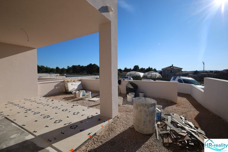 Construction work on the terrace of a holiday apartment in Vodice, sunny day, visible containers and materials.
