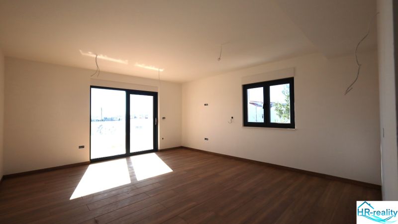 Interior of a vacation apartment with large windows and a wooden decor floor.