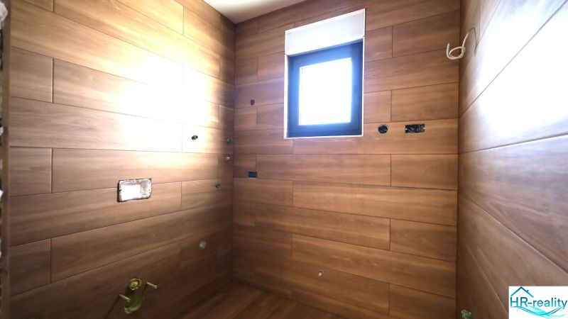 Recreational apartment with wood decor tiles and a small window.