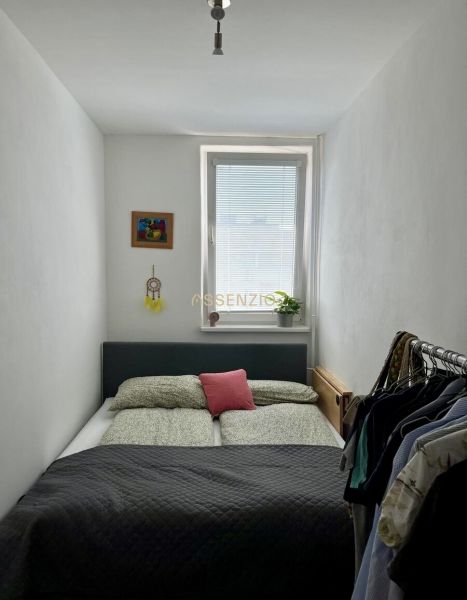 A cozy bedroom with a bed, a painting, and a wardrobe in a 2-room apartment.