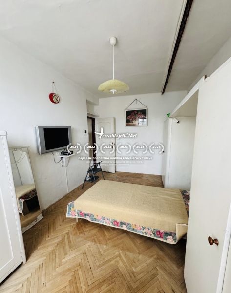 A bedroom with a mattress, a television, and a wooden decor floor in a 3-room apartment.