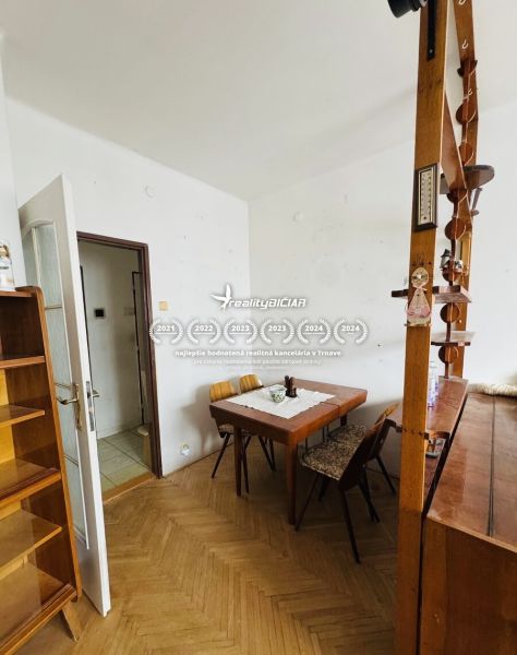 Dining room with a wooden table in a 3-room apartment, floor with wooden decor.