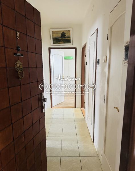 Entrance hallway of a 3-room apartment with tiles and a picture above the door.
