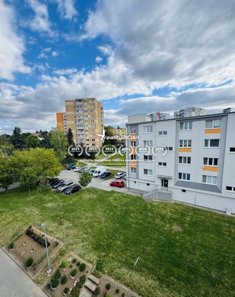 A view of residential buildings and a parking lot on Za poštou street in Hlohovec.