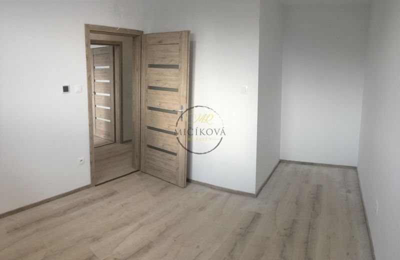 A room in a 3-room apartment with a wooden decor floor and light walls.