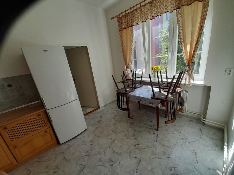 Kitchen in a 4-room apartment with large windows, a table, and a refrigerator.