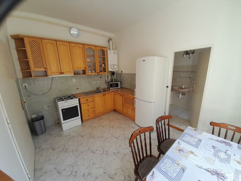 Kitchen in a 4-room apartment with a gas stove, refrigerator, and dining table.