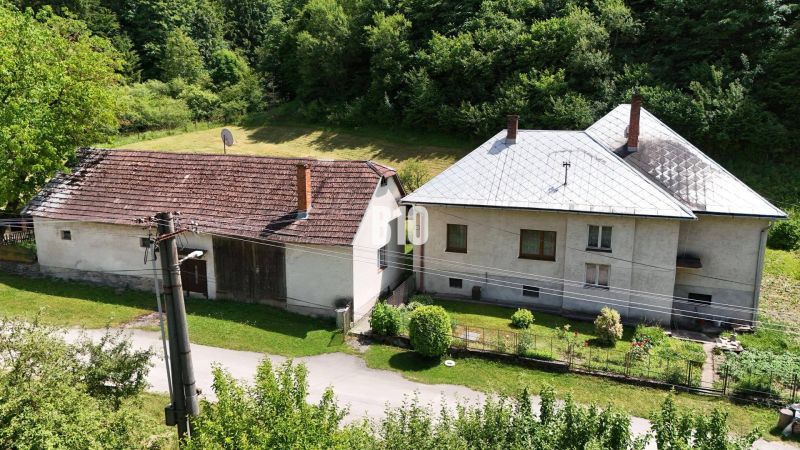 A family house in Belá-Dulice, with an extension, in front of a forest and a garden.