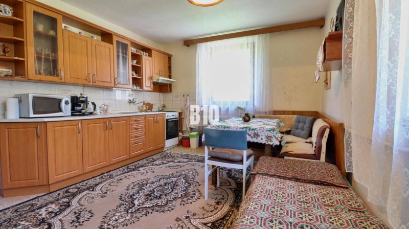 A kitchen in a family house with wooden furniture and a dining area.