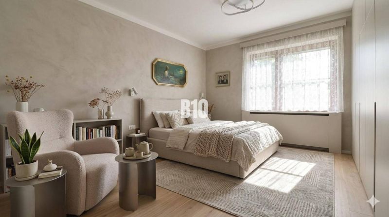 A bedroom in a family house with light walls, a bed, a chair, and decorations.