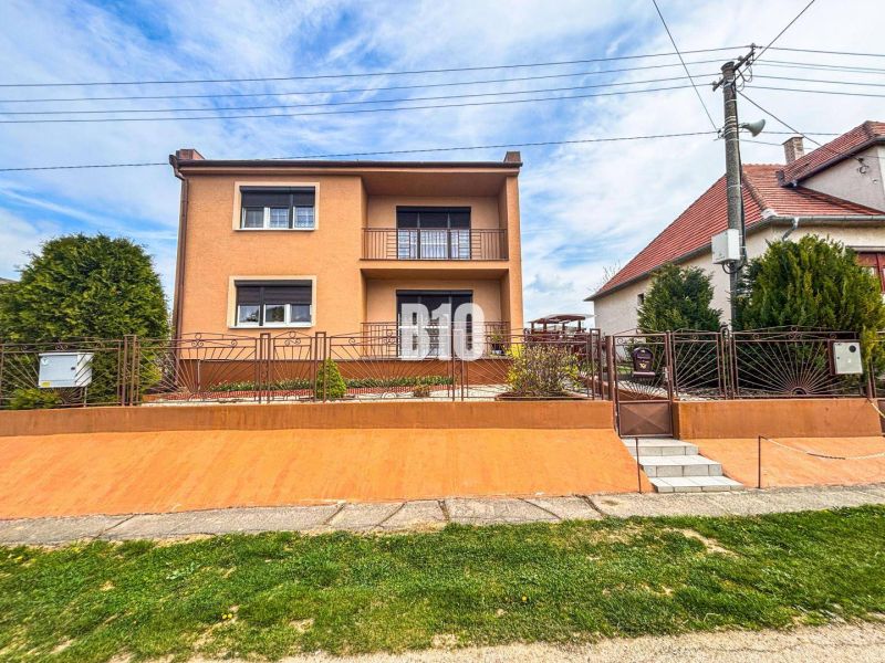 A family house in Lukáčovce with a garden and an elevated entrance surrounded by a fence.