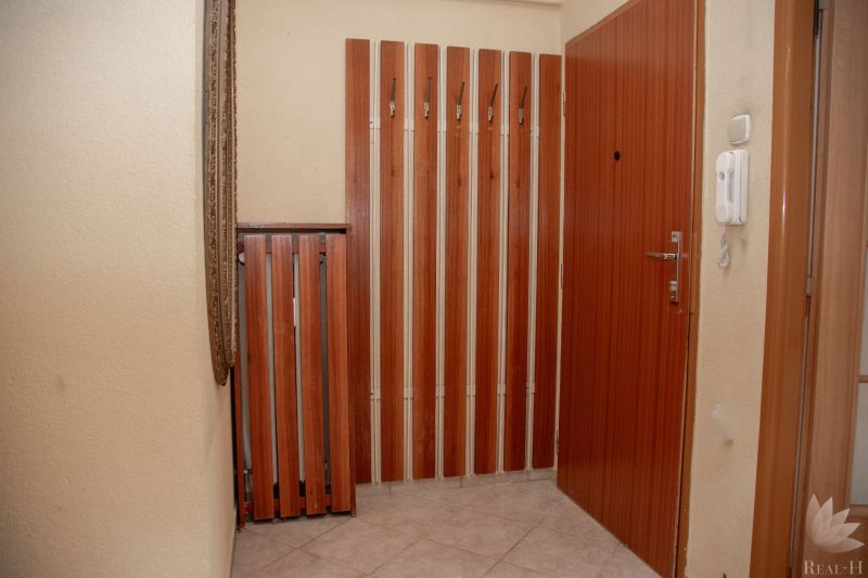 Entrance hallway in a 2-room apartment with coat hooks and a mirror on the wall.
