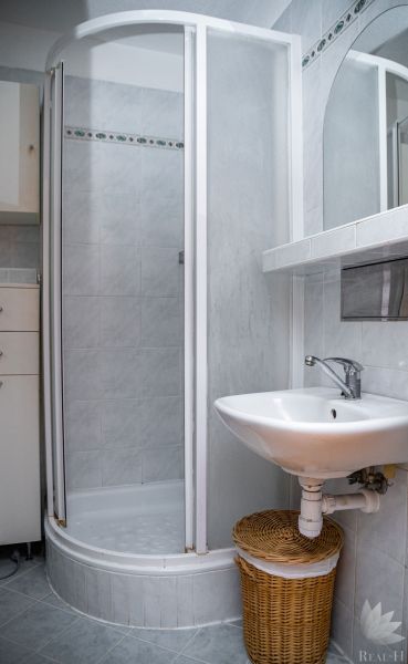 Bathroom in a 2-room apartment with a shower and a sink.