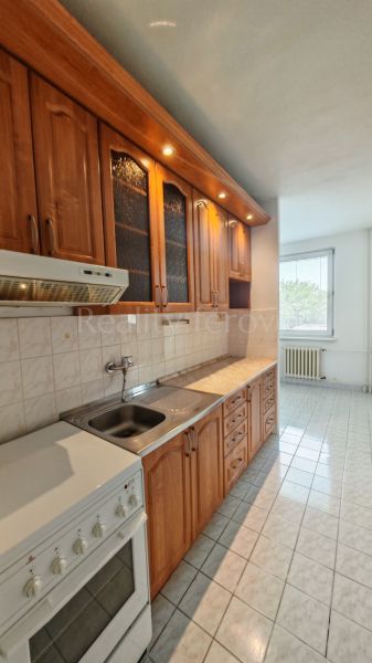A kitchen unit with wood decor and a stove in a 2-room apartment.
