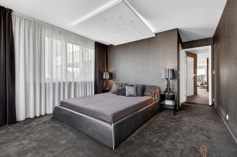 Bedroom in a 4-room apartment with a dark carpet and decorative walls.