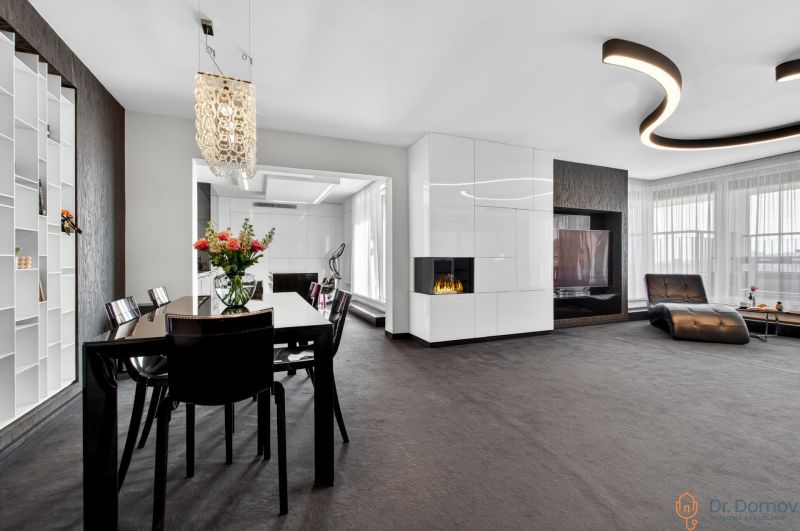 Living room in a 4-room apartment with a fireplace and a dining table with flowers.