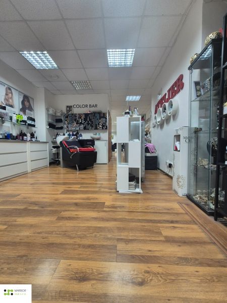 Commercial premises with wood-patterned flooring and hairdressing equipment.