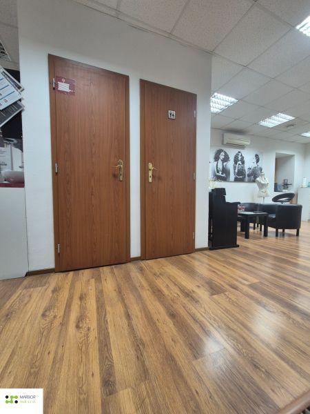 Commercial premises with a wooden decor floor, doors, and wall decoration.