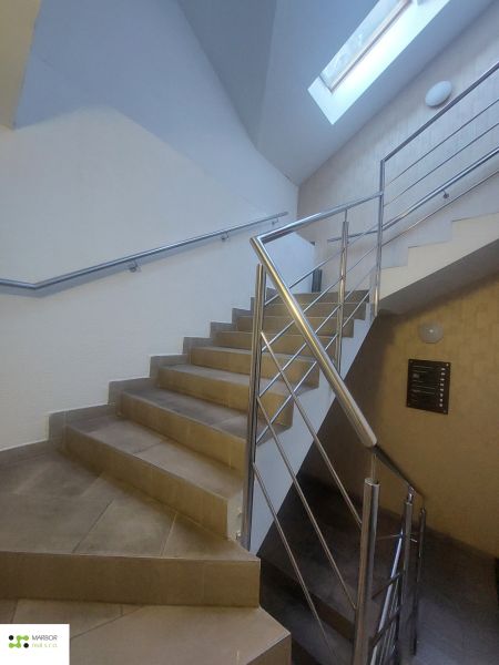 A staircase with stainless steel railing and natural light in commercial premises.