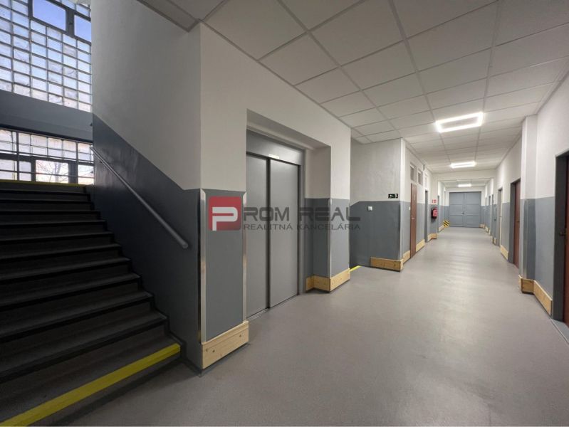 Hallway with stairs, elevator, and gray walls in the building Warehouses and Halls.