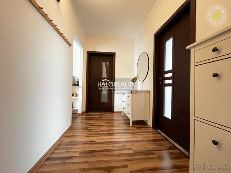 A hallway in a 3-room apartment with a wooden decor floor and white furniture.