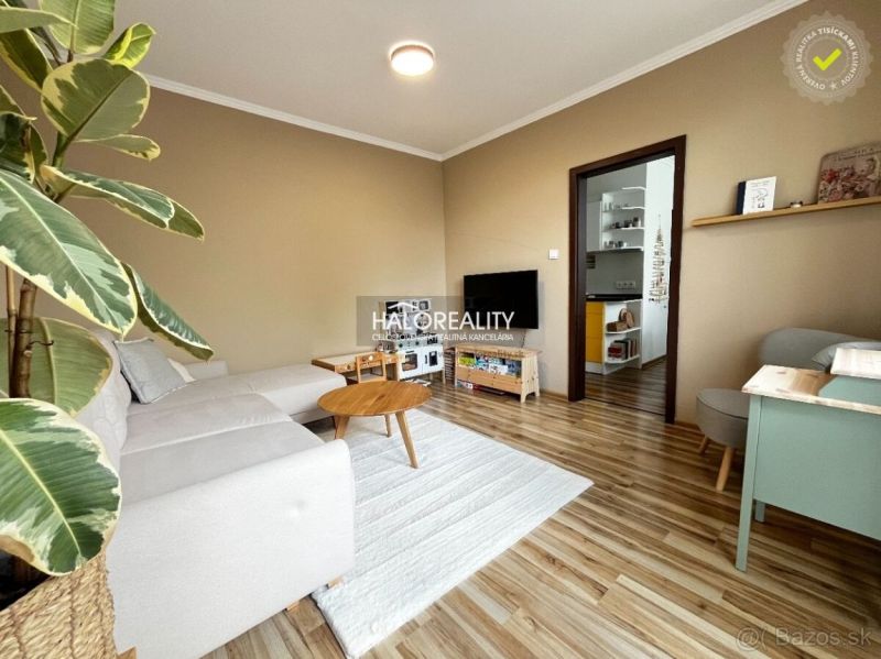 Living room in a 3-room apartment with a wooden decor floor and a comfortable sofa.