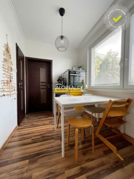 A kitchen in a 3-room apartment with a white table and a wooden decor floor.