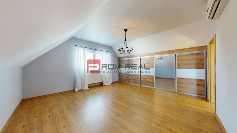 A room with a wooden decor floor and a built-in wardrobe in a family house.