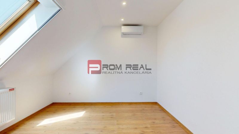 A room in a family house with a wooden decor floor and a skylight.