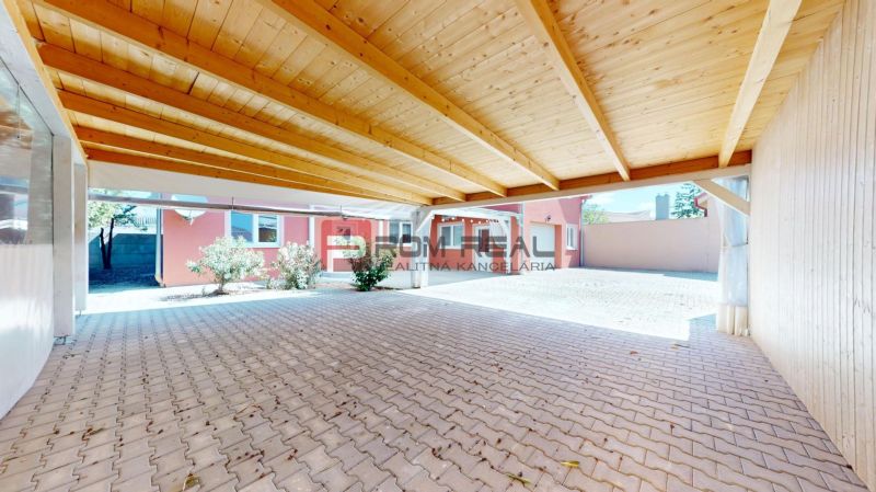 A shelter at a family house on Gútorská Street in Šamorín with a wooden ceiling and paving.