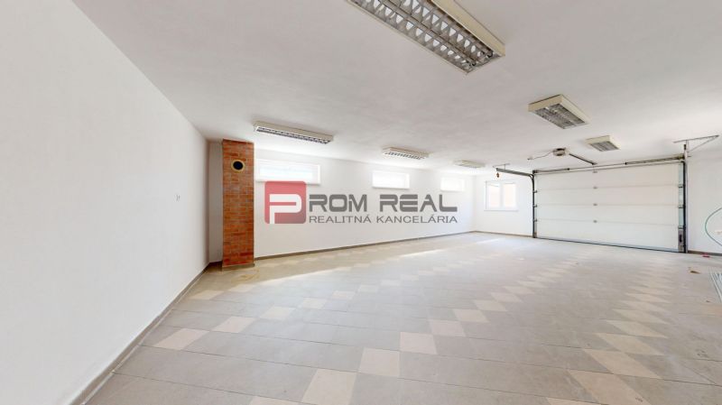 A spacious garage in a family house with white walls and panel lighting.