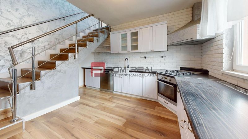 A kitchen with a wooden decor floor in a family house, modern equipment, and stairs.