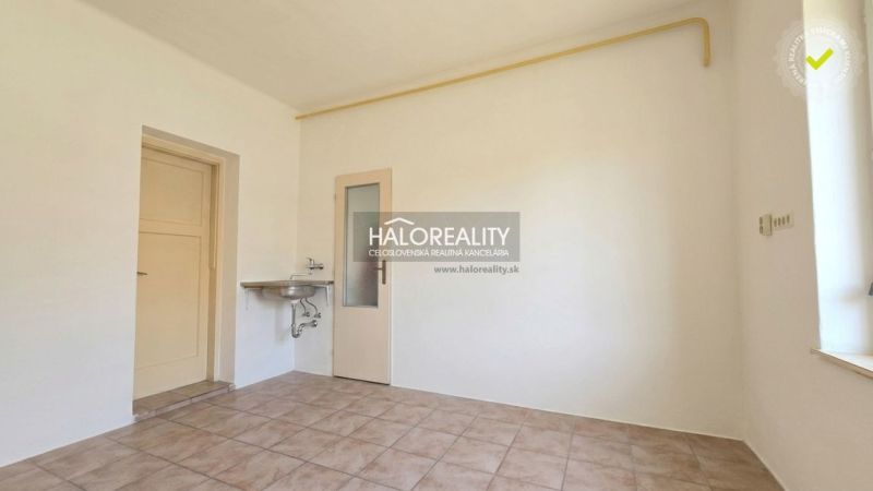 Empty room with a sink and tiles in a family house.