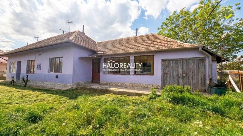 A family house in the village of Lok with a purple facade and a large garden.