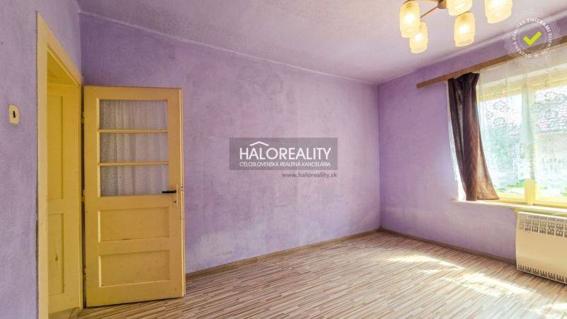 A room in a family house with purple walls and a wooden decor floor.