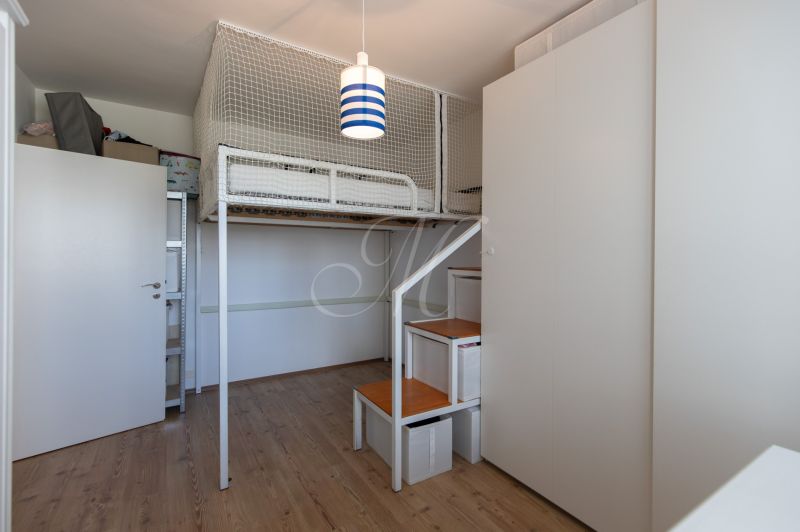 A children's room with a bunk bed and a wooden decor floor in a 2-room apartment.